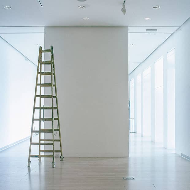 L'entré d'un hall d'immeuble vide sans boîtes au lettres une échelle dans le couloir, entrée moderne murs et sols blancs